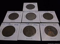 Seven British coins from 1896-1913, displayed in cardboard holders with year and identification notes handwritten.