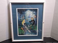 Framed and matted lithograph showing Princess Aurora and Prince Phillip in forest with animals, castle visible in background