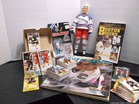 Wide shot including Mike Modano figurine, 1999 Wayne Gretzky Tuff Stuff magazine, assorted hockey cards, and Boston Bruins book