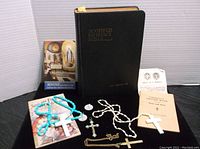 Overall lot contents showing 1917 Scofield Reference Bible, Catholic prayer book, rosaries, crosses, and medallions.