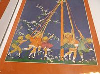 Photo showing an illustrated magazine picture of children playing around a maypole in a vintage scrapbook.