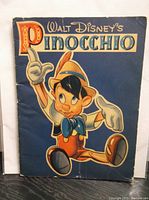 Front cover of the Pinocchio book showing colorful illustration of Pinocchio and title lettering.