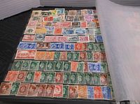 Page from the stamp book showing a variety of used vintage US stamps in multiple rows and colors, including historical figures.