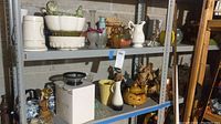 Shelving unit with upper and mid section showing various glassware, planters, teapots, and decorative items.