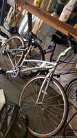 Silver Specialized Crossroads bike in garage showing overall profile including saddle, pedals, and wheels