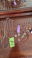 Full collection of chains, rings, bracelets, pendants, and earrings on wooden table