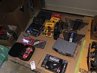 Overview of lot including drill, charger, drill bits, wrench sets, and laser level.