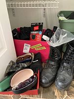 Photo of motorcycle boots, gloves, sunglasses, face masks, and balaclava in a box on the floor.