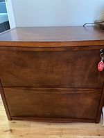 Front view of filing cabinet showing two drawers with a key in the lock on the top drawer