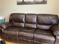 Front view of three-seat dark brown faux leather power recliner sofa