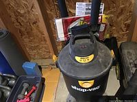 Photo of the Shop-Vac unit showing the brand, model capacity, and general condition.