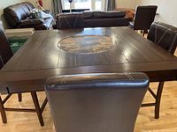 Front view showing square wood-look finish table with circular lazy Susan and six chairs around