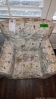 Child's upholstered armchair with world map print pattern, visible from front and top showing design details and size.