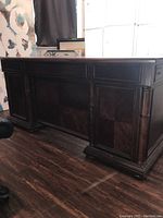 Front view of Havertys large wooden desk with closed drawers, dark wood, showing craftsmanship details