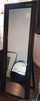 Large standing mirror with dark wide frame, shown upright with frame detail