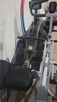 Close-up photo showing the rowing machine footrests with adjustable straps and cushioned seat area.