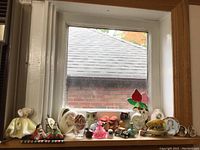 Wide view of collection on windowsill showing decorative eggs, small plates, and figurines