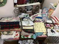 Varied linens, towels, place mats and more folded neatly on a table.