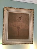 Framed ballerina print hanging on wall with detailed frame and matting visible