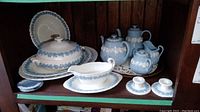 Overview of entire blue Jasper Ware and Queen's Ware porcelain set arranged on wooden shelf