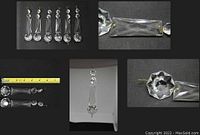 6 clear Swarovski lead crystal chandelier prisms each 5.5 inches long, arranged flat on a dark surface, showing overall length with a ruler.