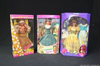 Front view of the three Barbie dolls in their original boxes: Australian Barbie, Pioneer Barbie, and Beauty and the Beast Belle Barbie.