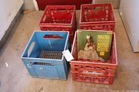 Four vintage milk crates with three red Sealtest and Dominion crates and one blue Beatrice Foods crate, shown with vinyl record (not included) for size reference.