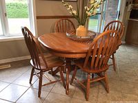 Front view of oak dining table with chairs around