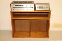 Sony STR-V2 stereo receiver and Realistic 31-1987 equalizer sitting on top of solid wood cabinet