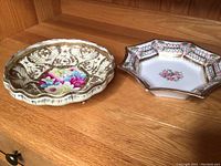 Both ornate Nippon bowls displayed side by side on wooden shelf, showing overall shape and decoration.