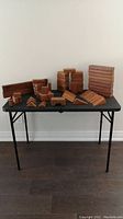 Full view of wooden blocks arranged on a black table showing multiple stacks and scattered shapes.