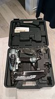 Complete kit including Hitachi air nailer, manual, nails, and carrying case opened and displayed.