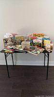 Full view of the entire collection of children's books displayed on a small black table.
