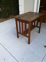 Full side angle showing rectangular table top and vertical slatted side panel details in solid wood.