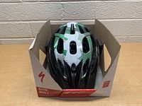Front view of Align adult cycling helmet in packaging, showing black and white helmet with green checkered pattern over top ventilation vents.