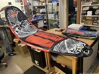 Photo of the inflated paddle board with A&B logo in black, red, and white colors.