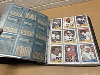 Photo of binder page showing 1988 Topps football cards front with players in uniform and card details.