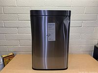 Front view of the Brightroom stainless steel touchless trash can showing a large dent on the right side.