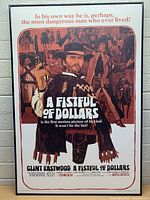 Full view of the framed movie poster showing Clint Eastwood with text and scenes from the movie.