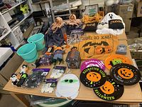Wide view of large assortment of Halloween decorations and party items laid on tables in storage area