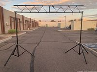 Full view of large stage lighting truss with adjustable tripod stands outdoors