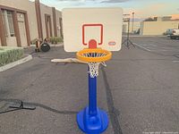 Front view of the Little Tikes basketball hoop showing white backboard with red square, orange rim, and blue stand with base.