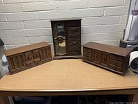 Three vintage wood jewelry boxes arranged on a table, showing their front and side views