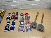 Photo of NHL hockey-themed metal spatulas with wooden handles, drink koozies, and coasters laid out on table.