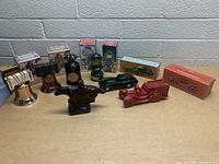 Photo showing all 10 vintage Avon collectible bottles, various shapes including bells, horse figurine, piano, lantern, vintage cars, and fire truck, some in original boxes.