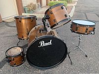 Pearl drum kit front view showing bass drum, two mounted toms, floor tom, and snare stand