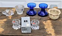 Full view of lot showing all candle holders including Mikasa Sparkling Star set in box, cobalt blue glass holders, frosted holder with leaf cutouts, ribbed clear glass holder, and star-shaped holder.