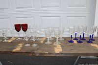 Full view of all 20 glasses arranged in rows showing red, blue, and clear glasses in assorted sizes and styles.