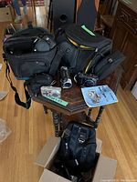 Overview of lot on table showing camera bags, cameras and accessories