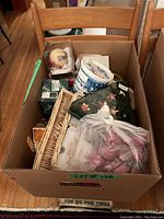 Box with an assortment of vintage Christmas ornaments including balls and various figurines in boxes and plastic bags.